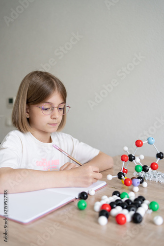 science and child with atom model for project, discovery or assignment. STEM education. Elementary science student using plastic atom model educational toy. 