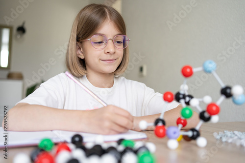 science and child with atom model for project, discovery or assignment. STEM education. Elementary science student using plastic atom model educational toy. 