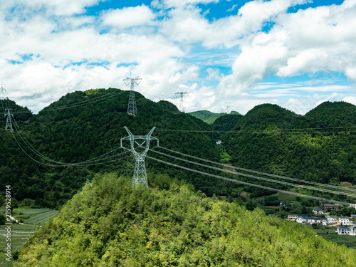 Bild auf Leinwand High-Voltage Transmission Towers in Mountainous Landscape