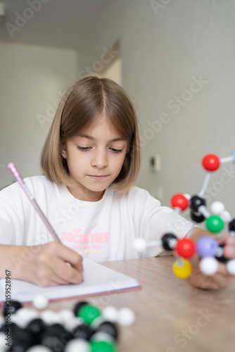 science and child with atom model for project, discovery or assignment. STEM education. Elementary science student using plastic atom model educational toy. 