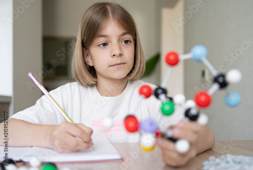 science and child with atom model for project, discovery or assignment. STEM education. Elementary science student using plastic atom model educational toy. 