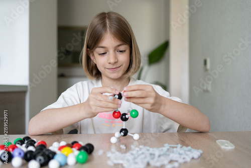 girl making molecular model learning chemistry science, home education. STEM 