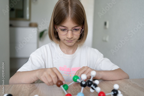 girl making molecular model learning chemistry science, home education. STEM 