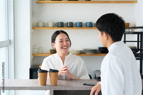 Young Japanese Woman Laughing and Talking with Cafe Staff at Counter