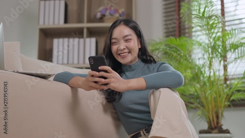 Excited asian woman celebrating good news on smartphone