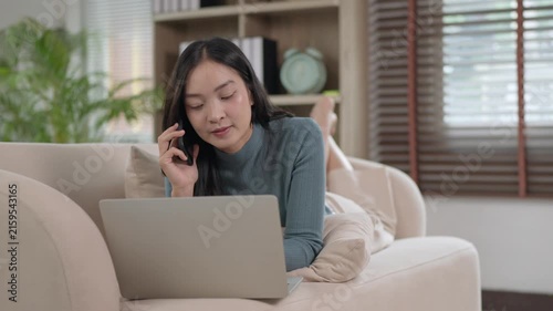 Asian woman working from home talking on phone