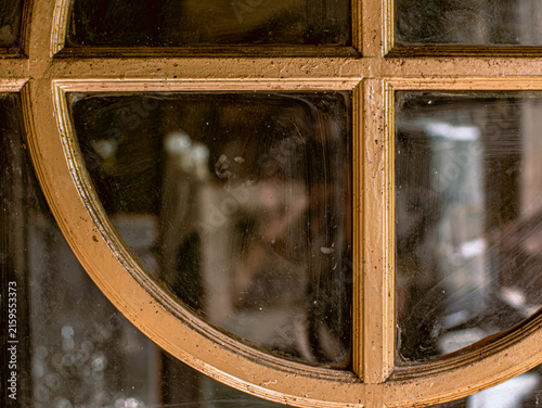 Close Up of Antique Gold Painted Window Frame with Dusty Glass and Blurred Reflection