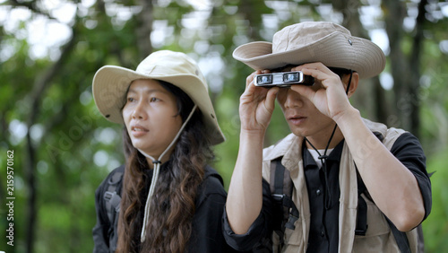 Картината върху платно Hiker Using Binoculars for Wildlife Observation in Forest