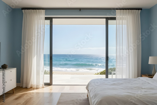 Modern coastal bedroom with panoramic ocean view, white linen curtains, light oak flooring, soft blue accents, breezy elegant styling, luxury beachfront residence