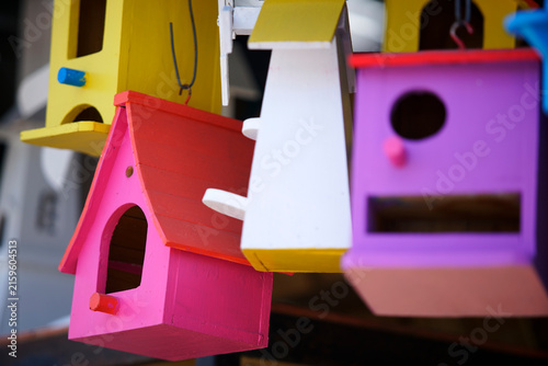 Colorful wooden bird house hanging outdoor with vibrant paint in sunlight