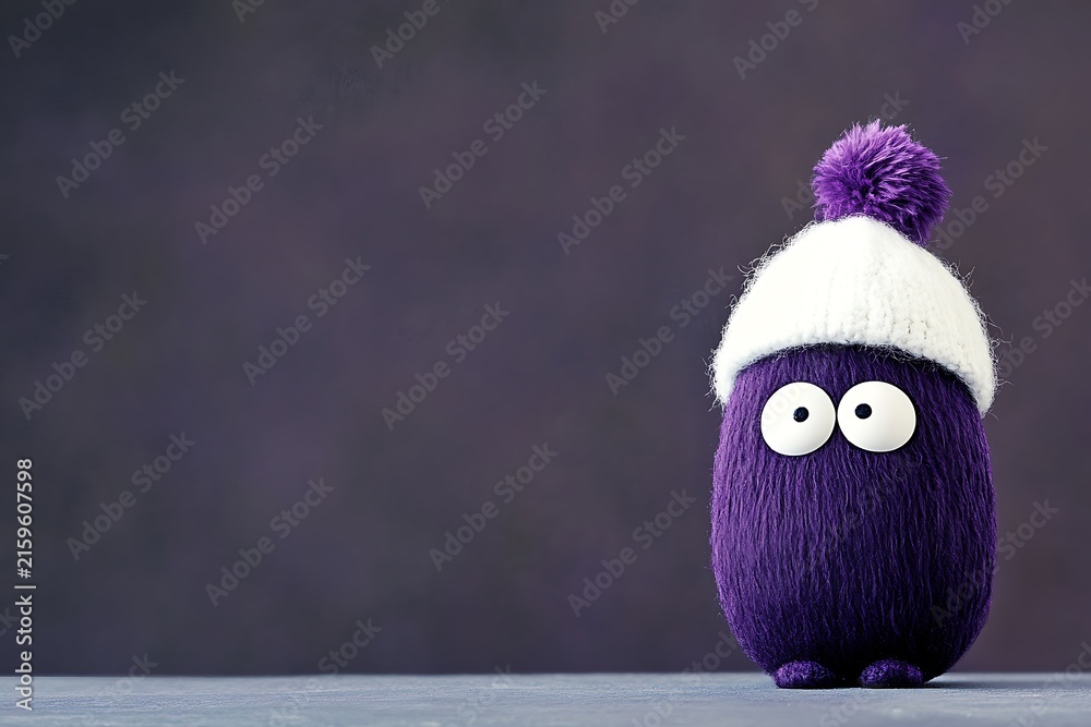 Fototapeta premium Purple stuffed toy with large eyes and winter hat