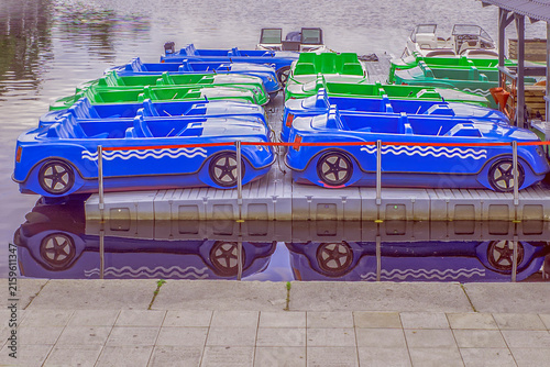 Rental water vehicles are parked on the river pier on a summer day