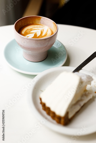 Cup of hot latte coffee on table by the window.
