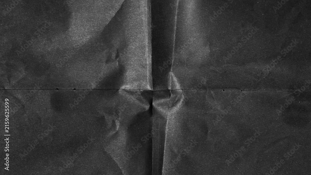 Naklejka premium Black paper background with creases that separates paper symmetrically into four parts