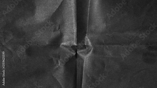 Black paper background with creases that separates paper symmetrically into four parts