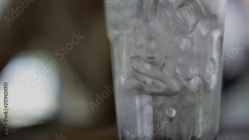 Pouring Fresh Water Into A Glass With Ice Cubes