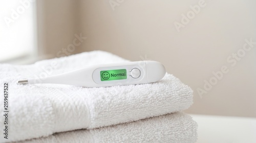 Digital Thermometer Displaying Normal Temperature on White Towel Background
