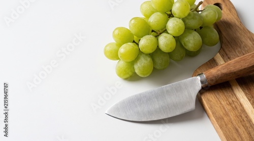 Fresh Green Grapes on Wooden Cutting Board with Stainless Steel Knife