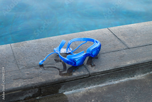 Konstfotografi Blue diving mask rests on wet stone edge