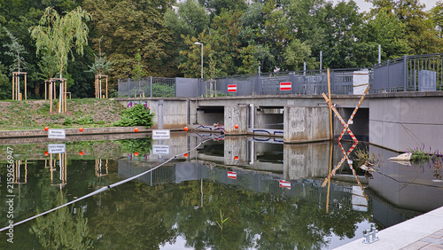 Blick auf den Blüthnersteg am Kanal mit Wasserspiegelung und umgebenden Bäumen an einem Sommertag – Leipzig, Sachsen, Deutschland