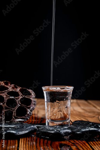Konstfotografi Pouring clear white liquor into the wine vessels placed on the wooden board creates countless bubbles