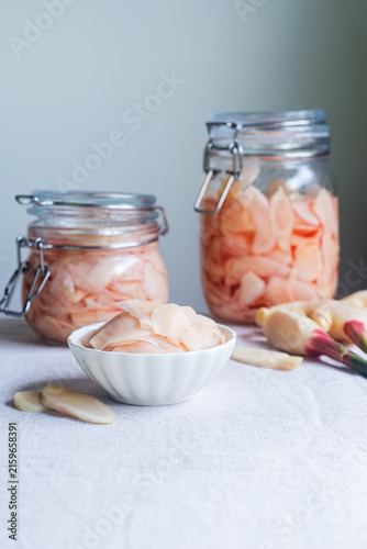 Canvastavla Pink pickled ginger slices in a small white bowl with glass jars