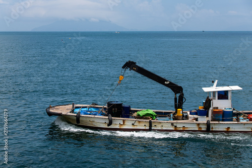 Small Aquaculture Work Boat with Hydraulic Crane Cruising Open Blue Sea