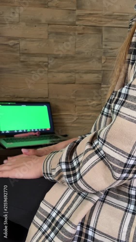 Woman attending an online therapy session via video call on a green screen laptop, gesturing while talking with a psychotherapist and seeking professional support