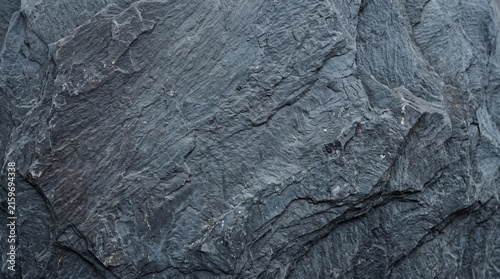 Close-up of rough slate stone texture with natural blue-gray mineral veins and rugged surface