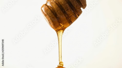 Honey dripping from wooden dipper