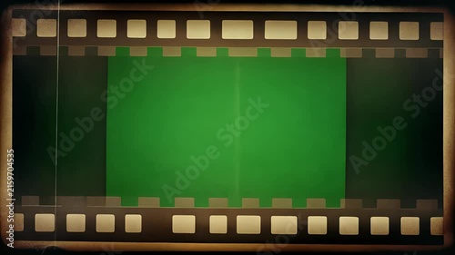 A vintage film reel with a green screen background.