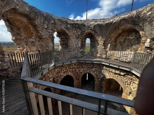 Cuadro en lienzo Ancient stone ruins with arched chambers and metal walkways, viewed under a brig