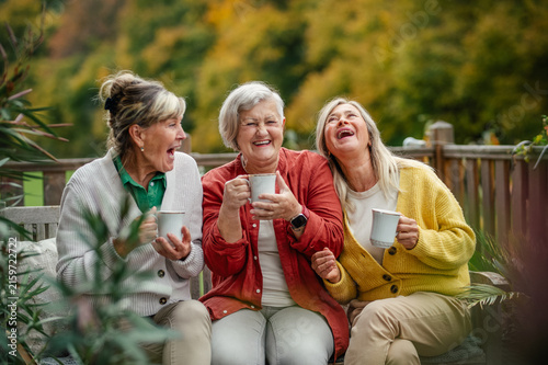фотографія Happy senior women enjoying cup of herbal tea together.