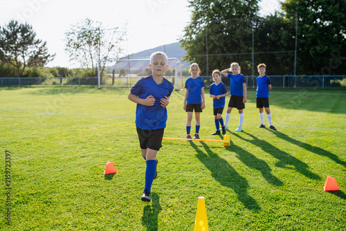 Картината върху платно Young athletes training footwork and coordination on soccer field