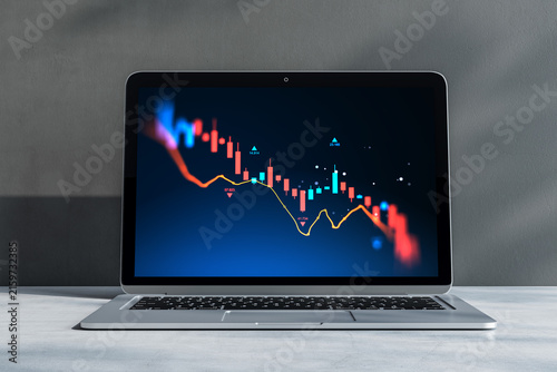 Fotografie Laptop screen displaying colorful descending stock market candlestick chart for trader, broker, and investor fintech analysis on dark background