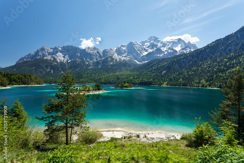 Travel landscape of Zugspitze Alps in Bavaria, Germany, scenic summer nature panorama with forest, Eibsee lake, snow mountains peak. Alpine landscape