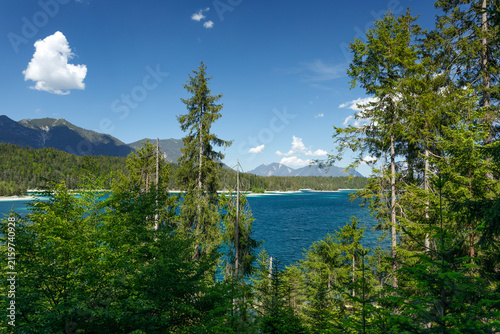 Travel landscape of Zugspitze Alps in Bavaria, Germany, scenic summer nature panorama with forest, Eibsee lake, snow mountains peak. Alpine landscape