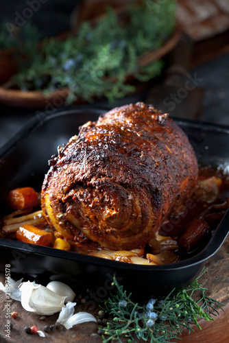 Rolled roast pork with braised vegetables in a pan indoors