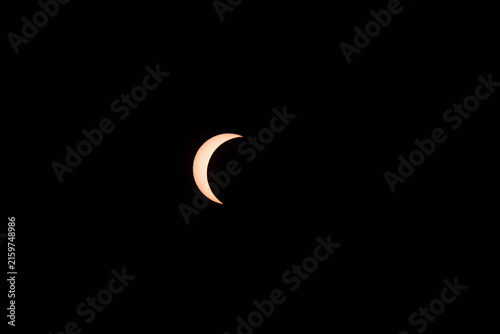 Partial Solar Eclipse Phase - Crescent Sun Against Dark Sky