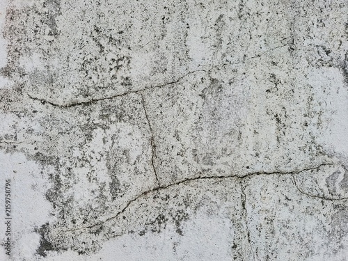 Cuadro en lienzo Cracked and Weathered Surface: A close-up view reveals a distressed concrete wall with prominent cracks and weathered texture, showcasing signs of age and decay