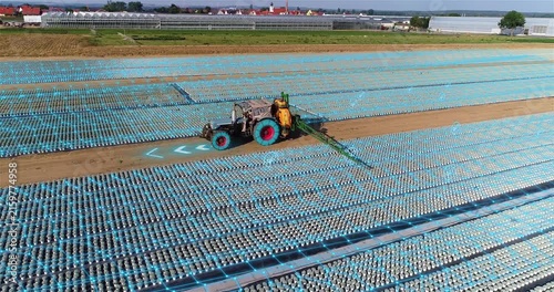 Smart Farming Tractor Working in Precision Agriculture Nursery with Digital Farming Technology. Autonomous Tractor Spraying Plants in Smart Agriculture Field with GPS Precision Technology