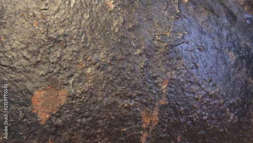 Foto Close-up texture of dark cast iron metal surface with patches of orange rust and rough industrial pattern