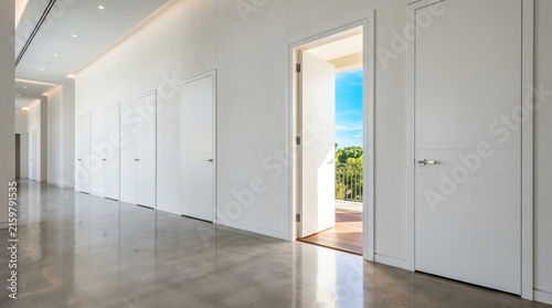 Modern interior hallway with white doors and open entrance to balcony