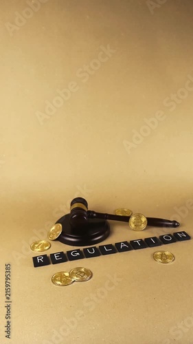 Conceptual video showing bitcoin coins with a judge's gavel and the word regulation on a brown background, symbolizing the legal oversight of cryptocurrency and digital assets