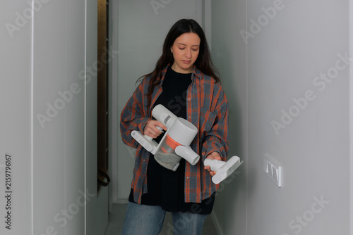 Konstfotografi Woman uses a vacuum cleaner in a hallway during daylight hours