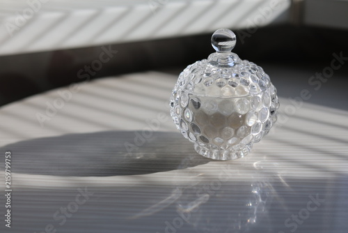 Fotografie Crystal glass trinket box with bubble texture and ball finial, catching sunlight
