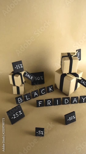 Handmade composition for a Black Friday event featuring craft paper gift boxes with black ribbons, sale tags, and discount percentages on a warm brown background with copy space