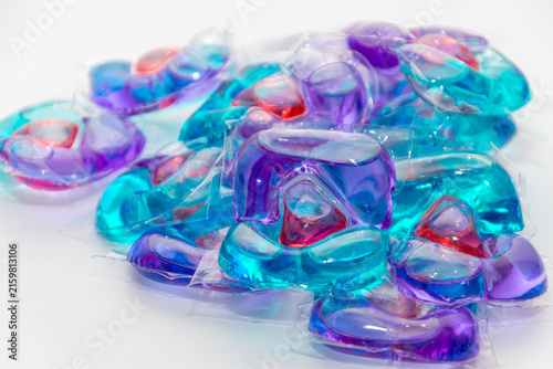gel capsules with laundry detergent on light background