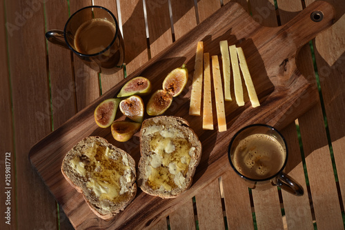 Rustic Mediterranean breakfast served outside on a wooden board
