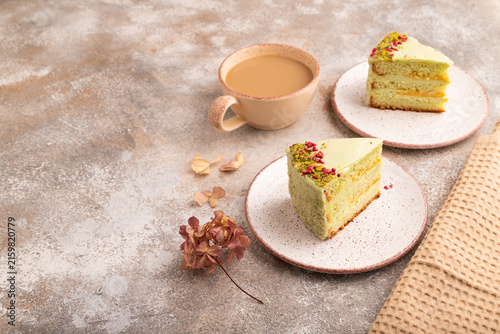 Pistachio green cake with cup of coffee on brown concrete, copy space, side view.